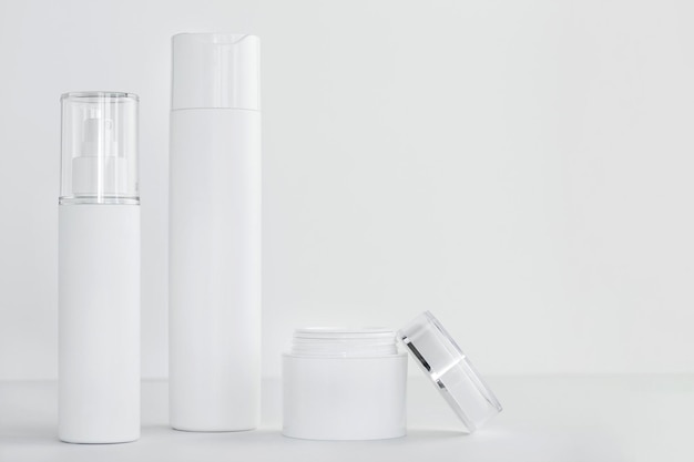 Set of white cosmetics containers on light background Copy space