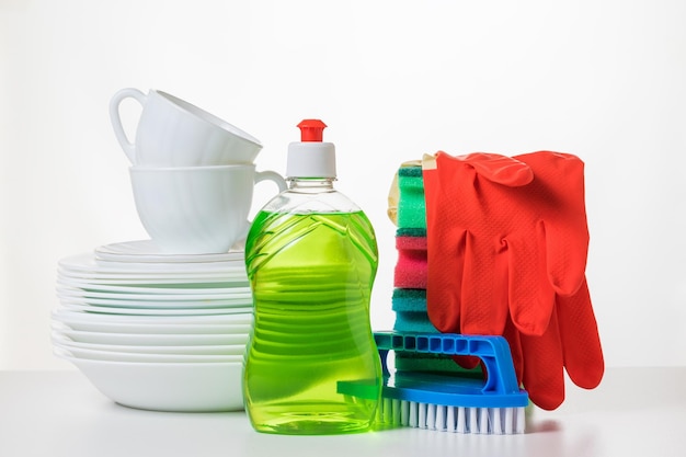 A set of white dishes and detergents on a white table
