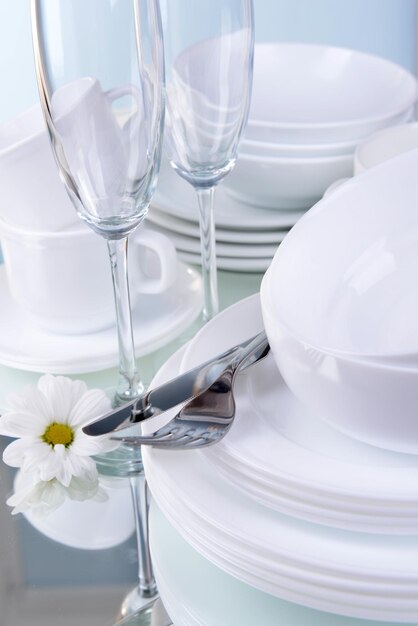 Set of white dishes on table on light background