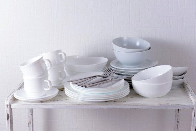 Set of white dishes on table on light background