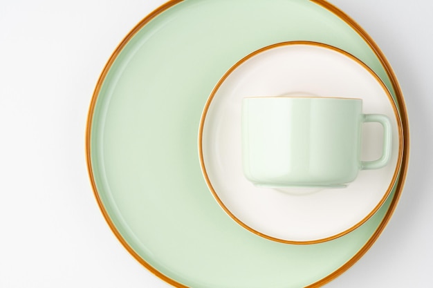 A set of white and pastel green ceramic tableware with orange outlines