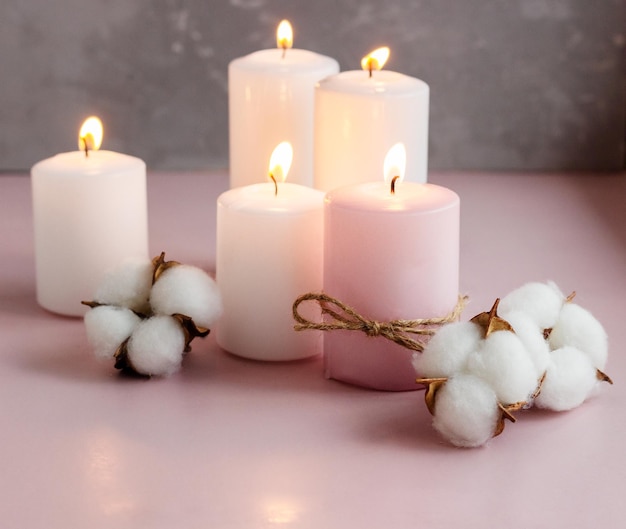 Set of white and pink wax candles with cotton flowers