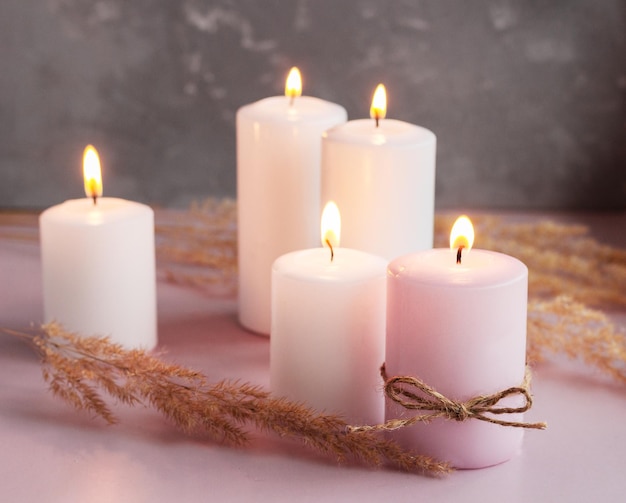 Set of white and pink wax candles with dried flowers