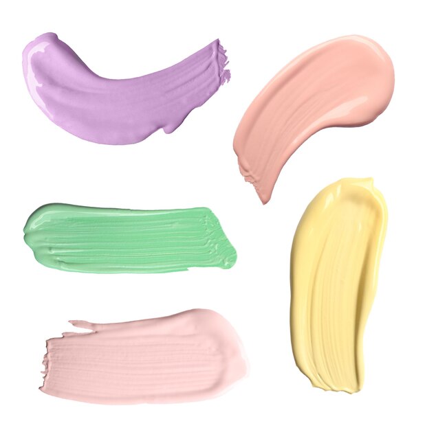 Photo set with strokes of color correcting concealers on white background top view