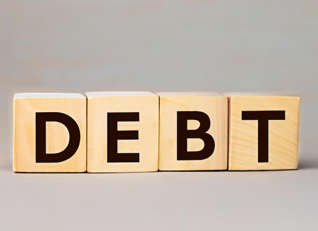 a set of wooden blocks with the word debt on them.