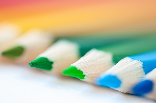 Set of wooden colored pencils crayons on a white paper close up selective focus