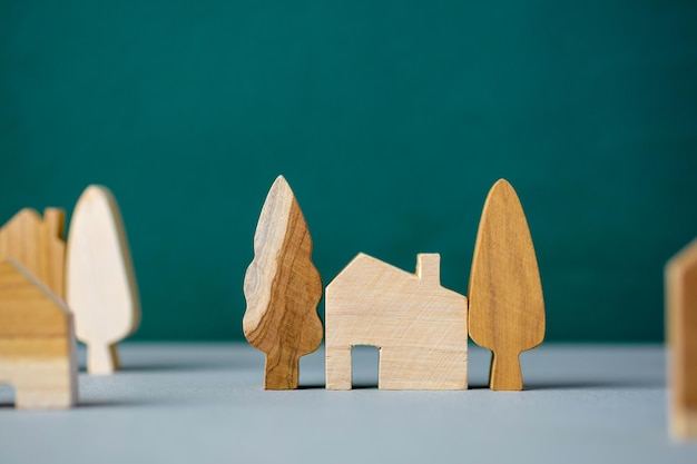 Set of wooden house and tree decoration in village on grey floor and green background