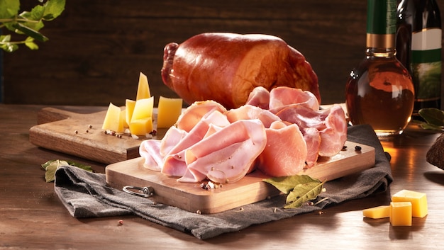 Set worstjes, salami, ham en gerookt vlees met rozemarijnkaas en kruiden op een donkere achtergrond. Delicate vleesproducten.