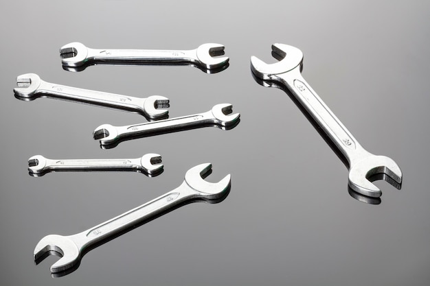 Set of wrenches on a gray background. Mirror surface. View on a plane.Copy space.Mirror surface.