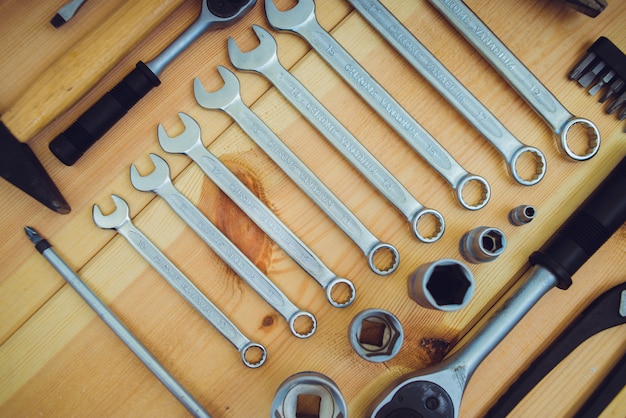 Set of wrenches and tools on wooden table