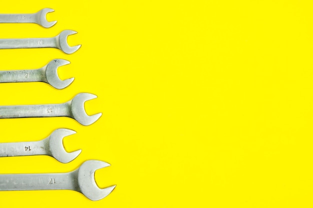 Set of wrenches on a yellow background.