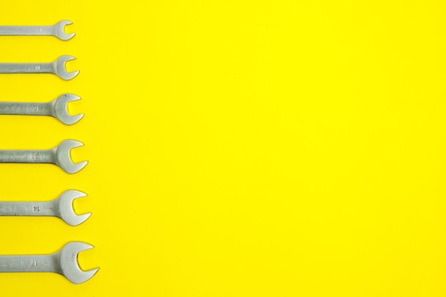 Set of wrenches on a yellow background.