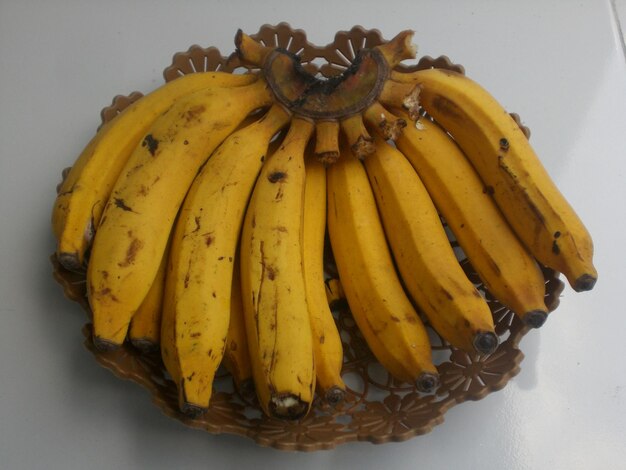 Set of yellow banana fruits on a wooden-like plate