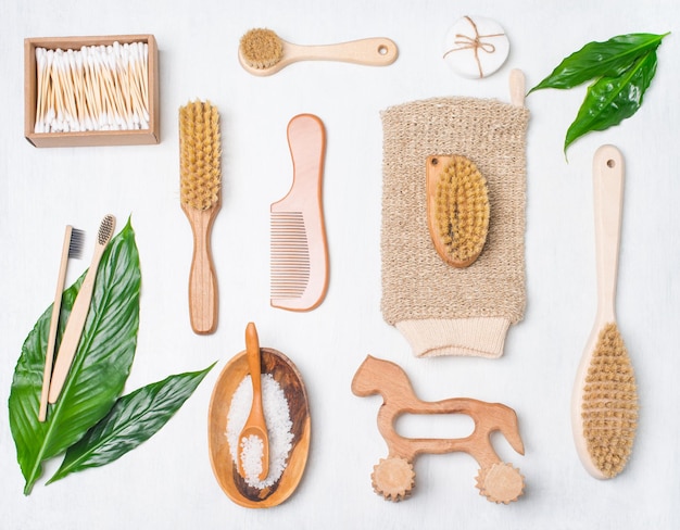 Set of zerowaste self care products on white background with green leaves