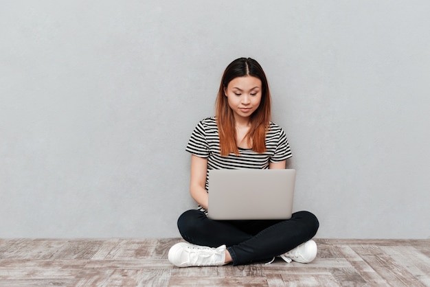 Setious vrouw die met laptop werkt