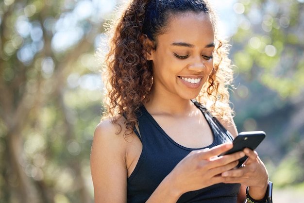 Setting the correct intentions Shot of a young businesswoman using her smartphone before a run