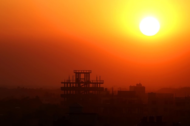 バングラデシュの建設ビルの後ろに沈む夕日