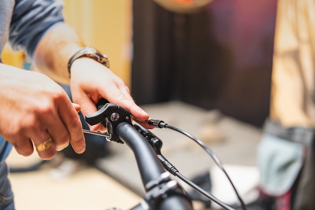 Setting up breaks of a bicycle, close-up view. Human hands repairing a bicycle at a local bike store