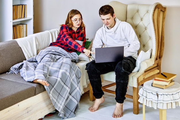 Setting up laptop to work from home colleague helps young woman prepare computer for teleworking