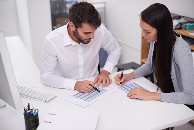 Setting up their monthly schedule Shot of two young business colleagues discussing documents in the office