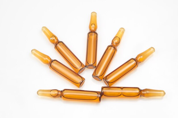 Seven medical glass ampoules for injection drug on a white background