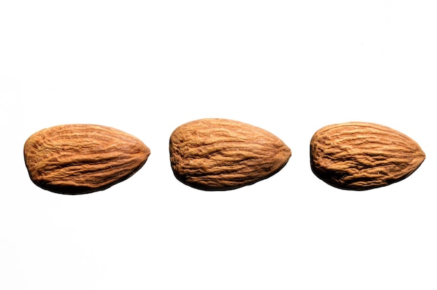 Photo several almonds on a white background. close-up. view from above.