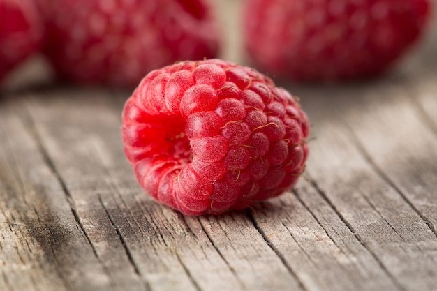 Several berries of raspberry on the old a wooden table close-up.