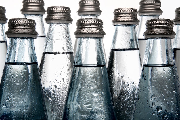 Several blue mineral water bottles with screw cap isolated on\
white background