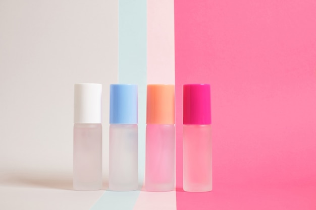 Photo several bottles of perfume of different colors on a bright colorful background