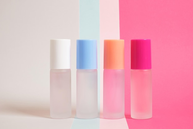 Photo several bottles of perfume of different colors on a bright multicolored background, mock up perfume bottles on a striped background, copy space, cosmetics background