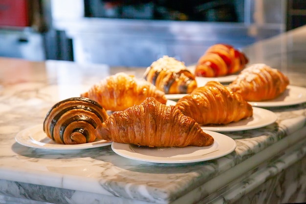 Several croissants are placed on the marble table before serving