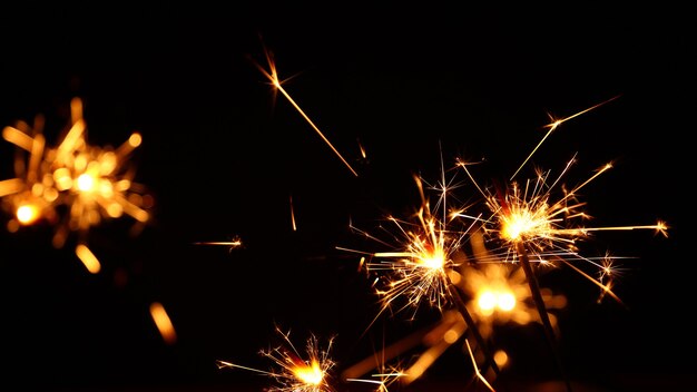 Several festive firework sparklers over black background