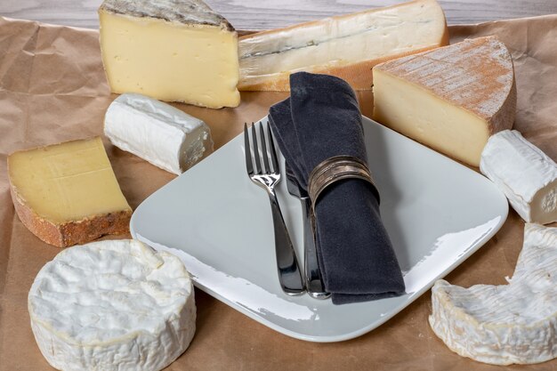 Several french cheeses with a plate