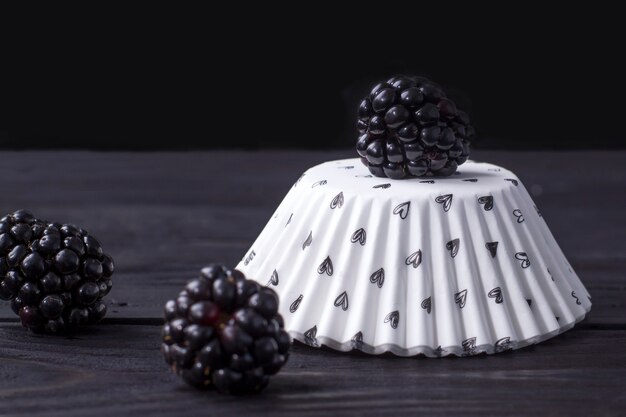 Several fresh blackberries on a dark background