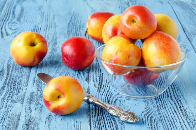 Several fresh peaches on a blue wooden