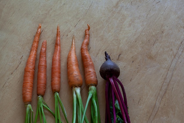 Several juicy natural unpeeled carrots on a chopping board