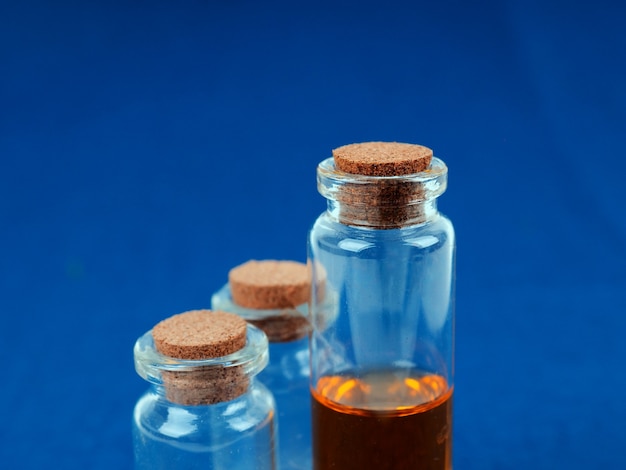 Several medical bottles, test tubes with a cork on a blue background.