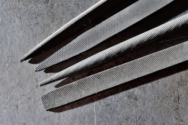 Several metal files are on the metal surface. close-up.