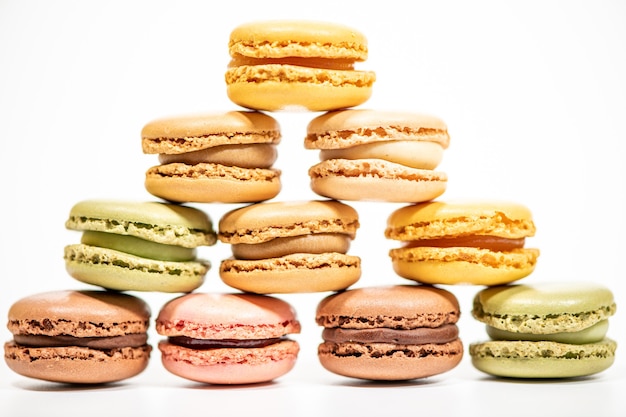 Several multi-colored macaron cakes on a white surface