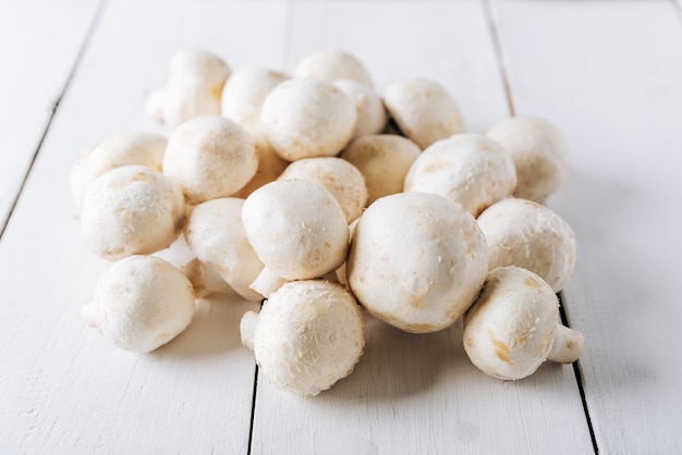 Several mushrooms on a white wooden background 1