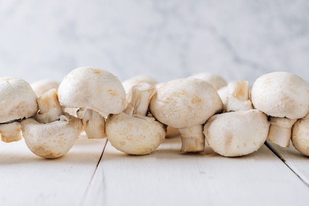 Several mushrooms on a white wooden table