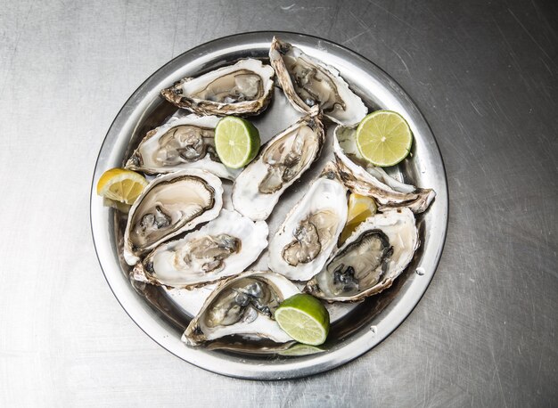 Several open oysters with lemon and lime.