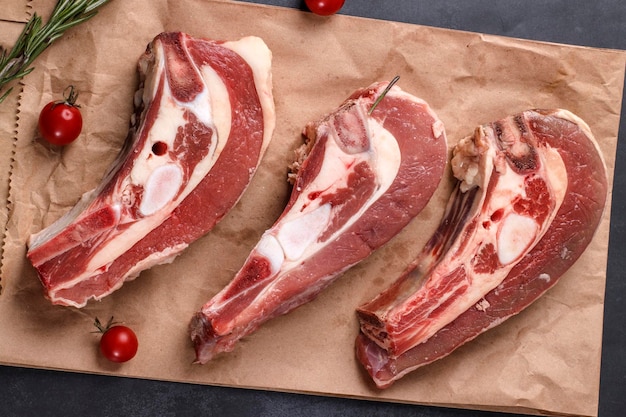 Several pieces of fresh raw beef brisket on the bone with cherry tomatoes