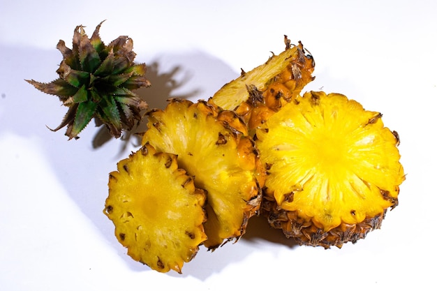 Photo several pieces of pineapple are served in bright yellow with a plain white backgournd