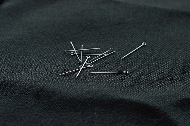 Several pins are scattered on the black cloth