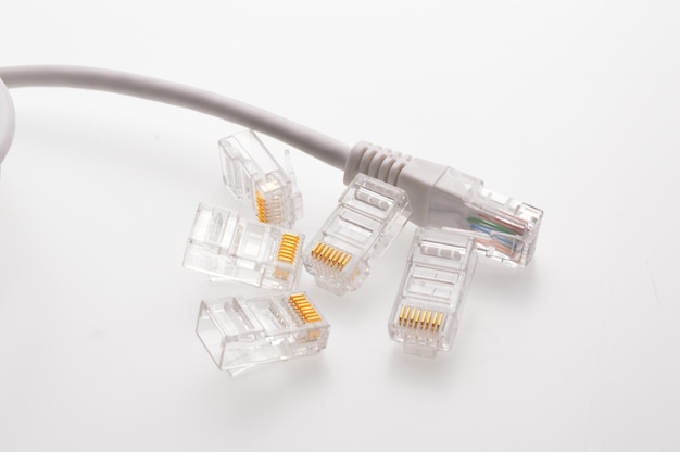 인터넷 케이블용 여러 개의 rg 45 커넥터가 밝은 배경에 놓여 있습니다.
