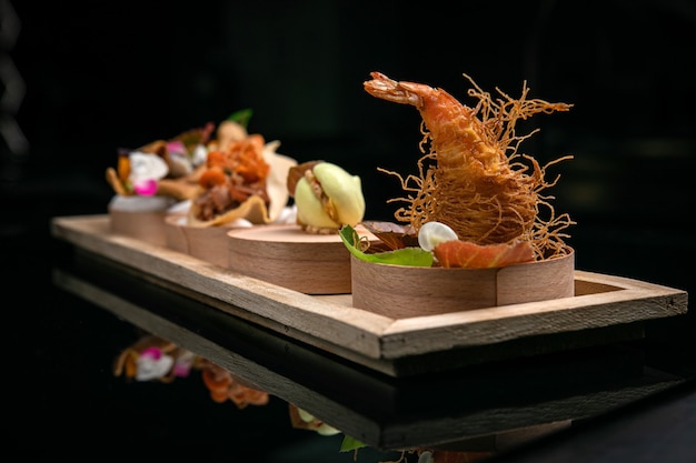 Several snacks for catering on a wooden board