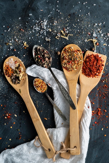 Several spoons with mix variaty of different spices poured on the tables