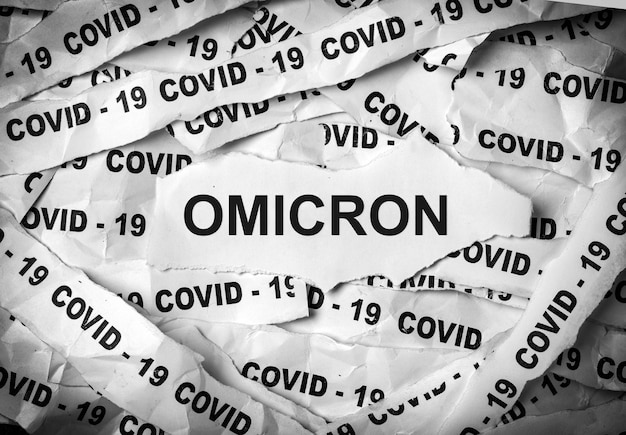 Covid-19とOmicronという言葉で印刷された数枚の紙片。 COVID-19の菌株の1つ。