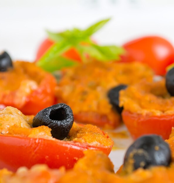 Several stuffed tomatoes on a ceramic plate